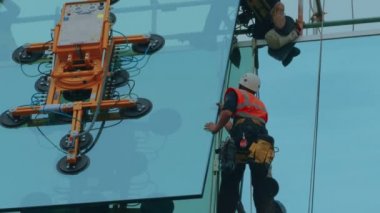 Yakın çekim çekim grup inşaatçılar yerde bir cam panel güvenliğini sağlama