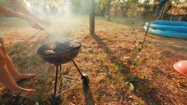 Tiros de ângulo ultra largo de jovem preparando carne de porco, carne bovina, aves domésticas e churrasco de frango (churrasco ) — Vídeo de Stock