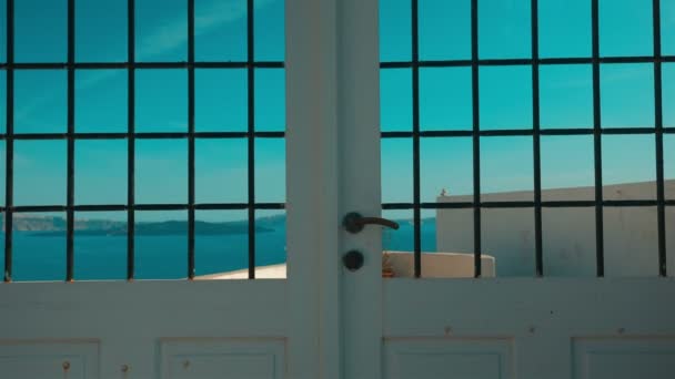 Langzame kantelbare opname van een typisch Cycladische mediterrane deur met uitzicht op de zee — Stockvideo