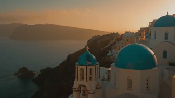 Estabelecendo o ângulo largo tiro de uma igreja cíclica tradicional cúpula azul e do mar Egeu — Vídeo de Stock