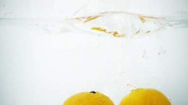 Süper ağır çekimde su içine sıçrayan iki mandalina