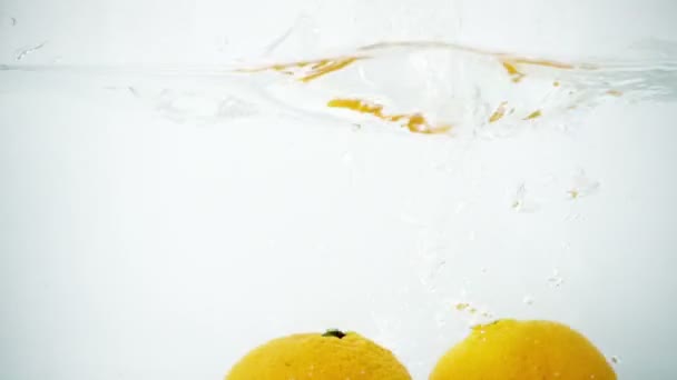 Deux tangerines éclaboussées dans l'eau en super ralenti 