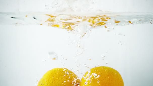 Deux tangerines jetées à l'eau dans un mouvement ultra lent 