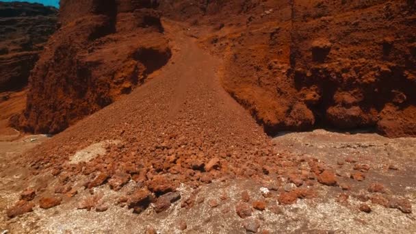 Inclinazione del colpo di una scogliera vulcanica rossa nella città greca di Akrotiri — Video Stock