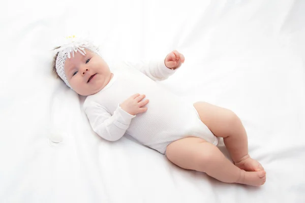 Маленькая новорожденная девочка лежит на кровати — стоковое фото
