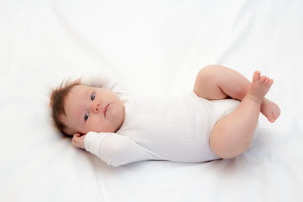 Маленькая новорожденная девочка лежит на кровати — стоковое фото