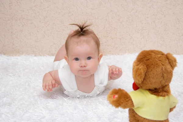 Menina bebê brincando com um ursinho de pelúcia de brinquedo — Fotografia de Stock
