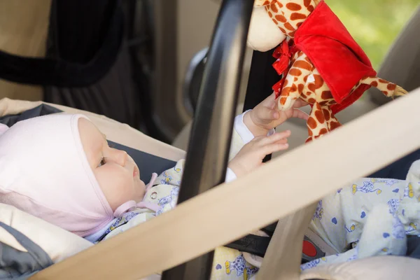 Little newborn baby girl rests in the car seat — Stock Photo, Image