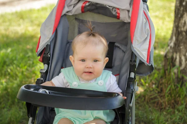 Niña sentada en un carruaje de bebé — Foto de Stock