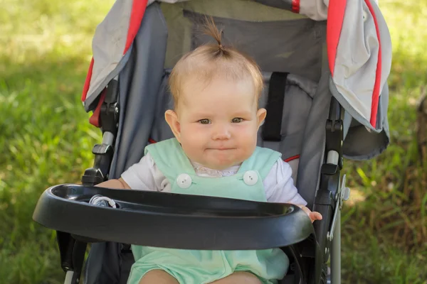 Niña sentada en un carruaje de bebé — Foto de Stock