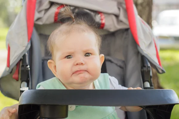 Niña sentada en un carruaje de bebé — Foto de Stock