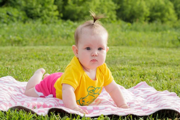 Pasgeboren meisje liggend op het gras — Stockfoto