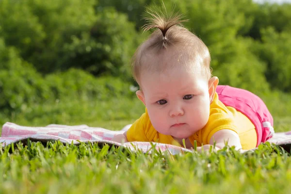 Novorozená holčička, ležící na trávě Royalty Free Stock Fotografie
