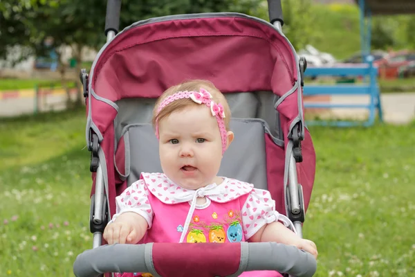 Pasgeboren meisje zit in een kinderwagen — Stockfoto