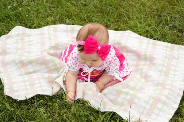 Pasgeboren meisje zittend op het gras — Stockfoto