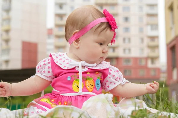 Pasgeboren meisje zittend op het gras — Stockfoto