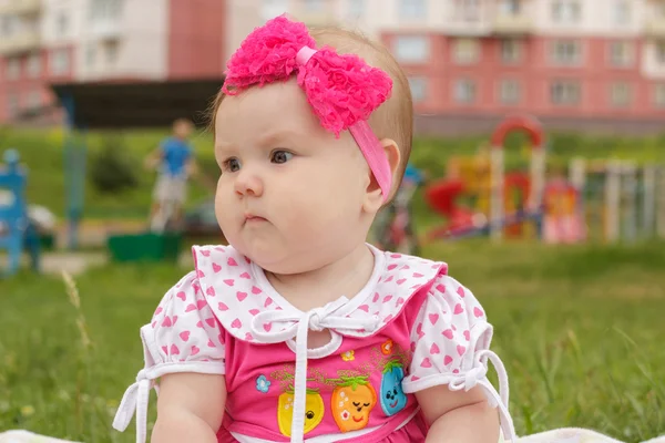 Novorozená holčička, sedět na trávě Stock Snímky