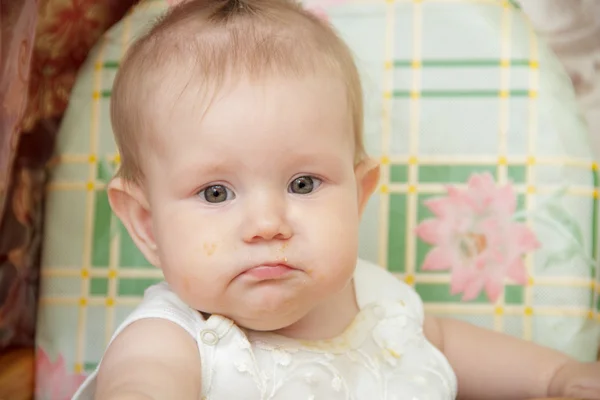 女の子子供ハイチェアに座っているし、クッキーを食べる — ストック写真