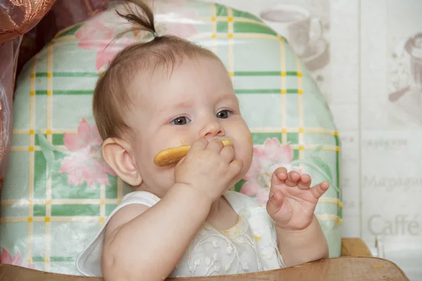 Malé dítě dívka sedí na vysoké židličce a snědl — Stock fotografie