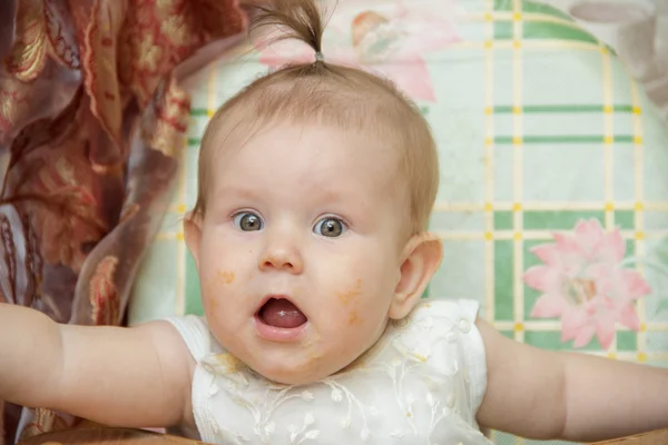 Bambina si siede in un seggiolone e mangia biscotti — Foto Stock