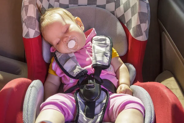 Маленькая новорожденная девочка отдыхает в автомобильном кресле Стоковая Картинка