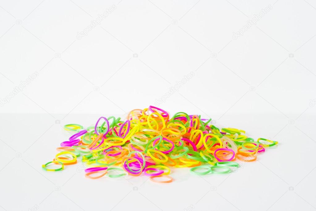 Rainbow loom- Colored rubber bands for weaving accessories on a white background