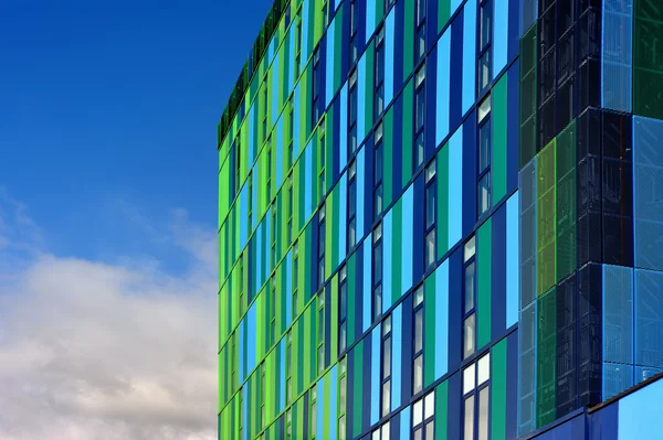 Fachada de vidrio colorido con cielo nublado — Foto de Stock