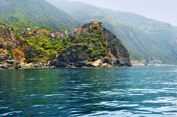 Uitzicht vanaf de zee op dorp Corniglia met terrasvormige wijngaarden — Stockfoto