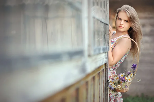Chica de campo en vestido de verano con una cesta de flores silvestres —  Fotos de Stock