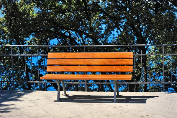 在一个阳光明媚的日子里, 公园里的水附近的长凳 — 图库照片