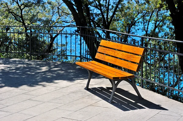 在一个阳光明媚的日子里, 公园里的水附近的长凳 — 图库照片