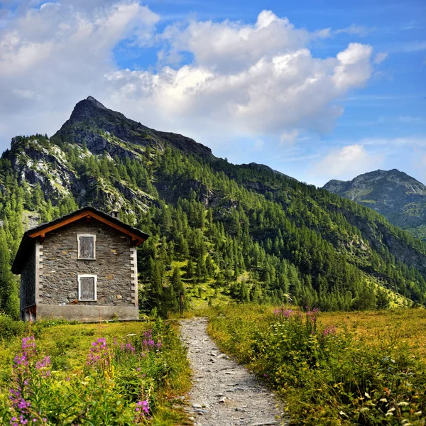 Old shelter with path in alpien mountains landscape — Stock Photo, Image