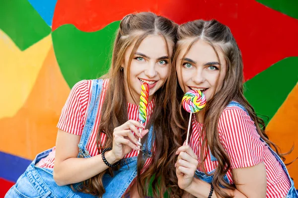 Irmãs Gêmeas Adolescentes Roupas Coloridas Com Pirulitos Fundo Grafite Colorido — Fotografia de Stock