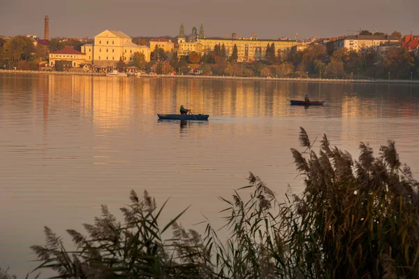 Ternopil şehrinin güzel manzarası bir tekne ile göl manzarası boyunca, gün batımının altın saatlerinde sazlıklar