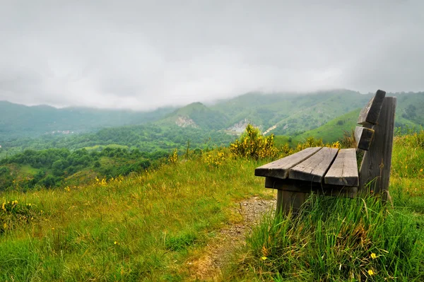 Lonely bench on a hill with mountain scenery — Stock Photo, Image