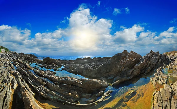 Pedra corredeiras no mar de céu azul com nuvens — Fotografia de Stock