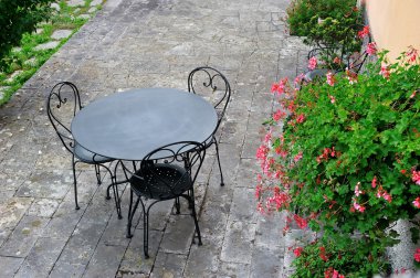 Masa, sandalye ve pembe çiçekli yaz güzel Bahçe Teras