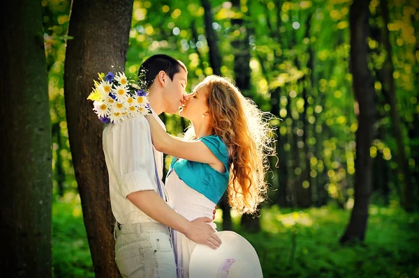 부케와 함께 숲 속에서 키스 하는 연인 — 스톡 사진