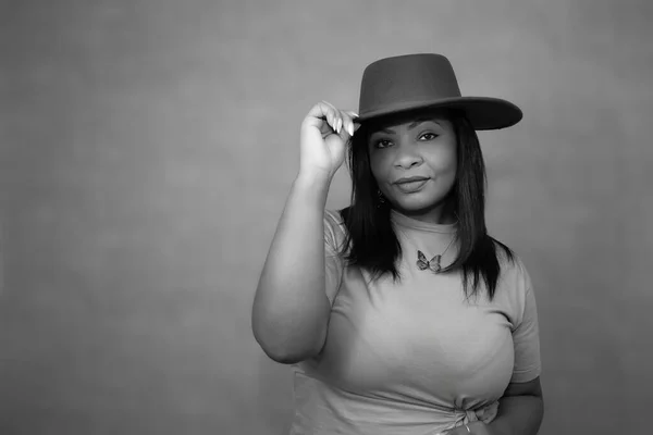 Kovboy şapkası takan güzel bir kadının siyah beyaz portresi. Kırsal kutlamalar, kır festivalleri, çiftlik yaşam tarzı ve batı temalı reklam kampanyaları için mükemmel..
