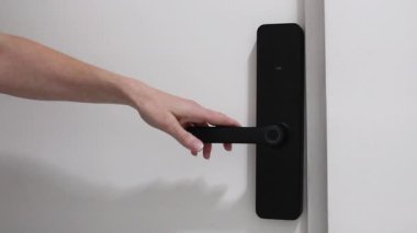 Kadın eli dijital biyometrik kilit kullanarak evin kapısını açıyor. Kopya alanı olan yatay video, akıllı ev aygıtları, konut güvenlik sistemleri ve modern teknoloji içeriği için ideal.