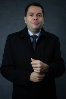 Siyah paltolu bir iş adamı dışarı çıkmaya hazırlanıyor. Stüdyo portresi kış mevsimi temaları, şirket iş hayatı ve zarif erkek modası için idealdir..