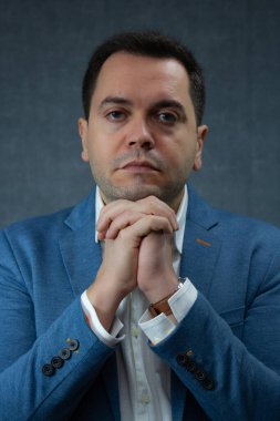 İşadamı çenesini sıkı sıkı tutarak dinleniyor. Şirket işleri, dini inançlar ve derin düşünceler için ideal bir stüdyo portresi..