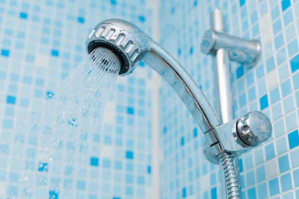 Working head shower on blue background — Stock Photo, Image