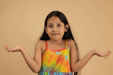 Açık kahverengi arka planda bir kuşku ya da kafa karışıklığıyla ellerini uzatan bir kız. Fotokopi alanı olan resim, reklam, eğitim veya kavramsal tasarım için ideal