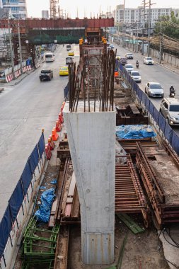 Şehirdeki gökyüzü treni inşaatı sabah saatlerinde güneş ışığıyla birlikte araç hareket bulanıklığı içinde.