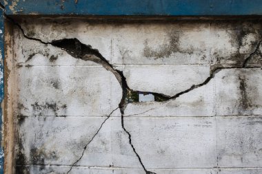 Eski beton duvarda bir şeyin çarpmasından kaynaklanan çatlaklar var.