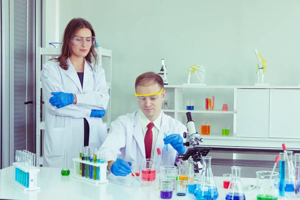Samec Vědec Nalévá Chemikálie Zkumavky Studovat Chemikálie Ženou Vědec Slouží Stock Snímky