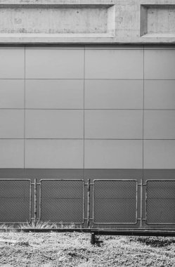 BTS istasyonunun koruyucu metal ağ tel örgüsü, arka plan ve çimen ön planına karşı siyah ve beyaz stil 