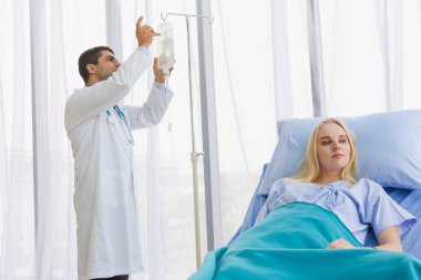 Erkek doktor, kadın hasta hastanede yatarken tuzlu su seviyesini kontrol et.