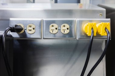 Duvardaki endüstriyel elektrik prizleri makinenin utenizasyonuna güç sağlamak için.